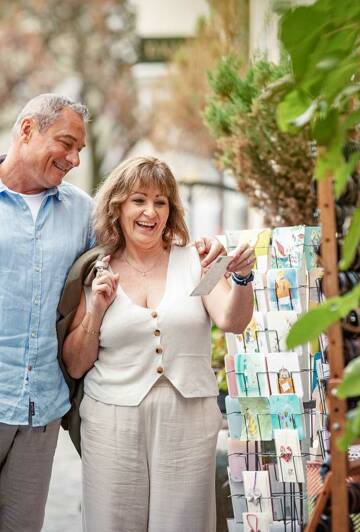 Besonders die Altstadt auf der Lindauer Insel, mit ihren charmanten Gassen und historischen Gebäuden, bietet ein vielfältiges Angebot. Älteres Paar am Schlendern