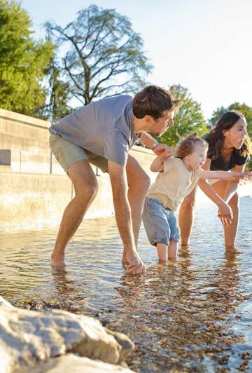 Der Bodensee ist der größte See Deutschlands und grenzt an Österreich und die Schweiz. Unzählige Strandbäder und Badebuchten laden im Sommer zum Schwimmen ein. Familie planscht im Bodensee