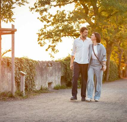 Entdecken Sie das Vierlinden-Quartier aus jeder Perspektive – ganz bequem von Zuhause aus. Mit unserer virtuellen Tour spazieren Sie durch das gesamte Quartier. jüngeres Paar schlendert
